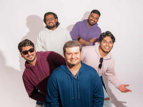 A diverse group of people smiling in comfortable activewear in a modern studio.
