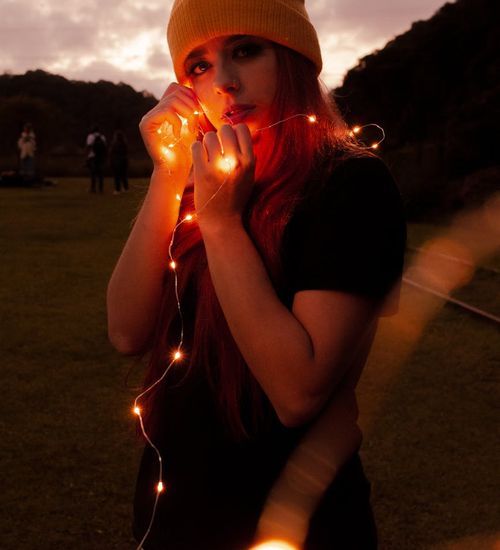 Silhouette of a person in a calm stretch pose against a dark background with neon glow.